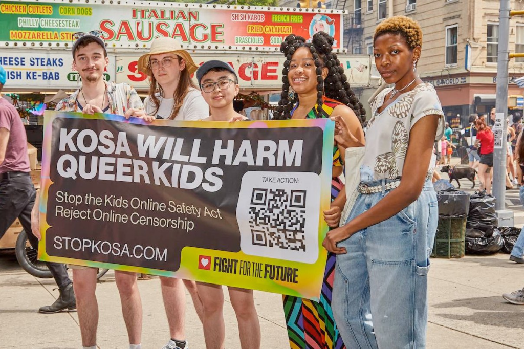 A group of young people hold a sign that reads "KOSA will harm queer kids" at a Pride event in Brooklyn