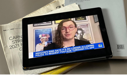 An iPad on a table shows a still of Evan Greer on MSNBC. The caption reads "Amazon's Ring says it's no longer allowing police to request footage through its app".